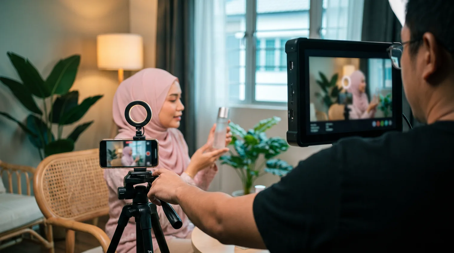 A local team filming a short skincare video with a Malaysian presenter in a home-style studio set